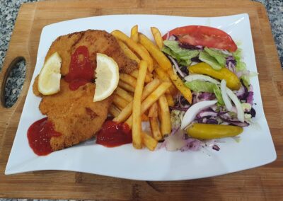 ein paniertes schnitzel mit pommes und salat